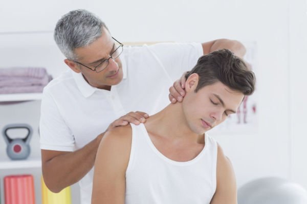 physical therapist working on man with neck pain