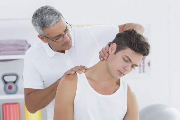 physical therapist working on man with neck pain